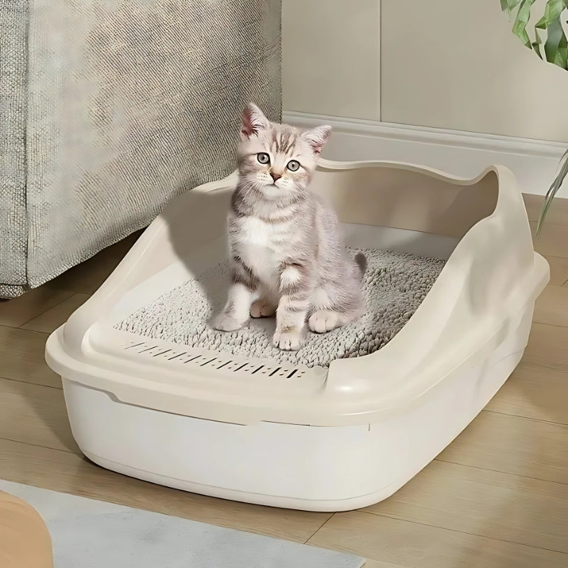bac a litière a bord haut beige pour chaton remplie de litiere vu du de coté avec un chaton faisant des besoin dedans