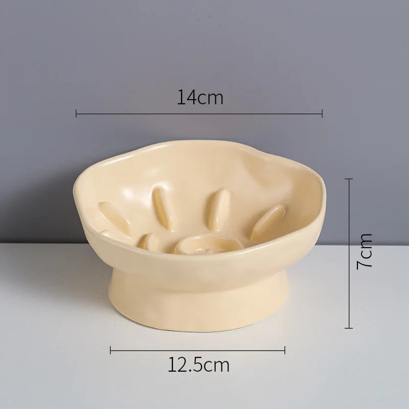 Dimensions de la gamelle anti glouton pour chat jaune crème : diamètre 14 cm, hauteur 7 cm et base 12,5 cm. Cette gamelle anti-glouton chat surélevée en céramique avec obstacles internes ralentit le repas. Une gamelle anti glouton ergonomique aux mesures précises pour la santé du chat.