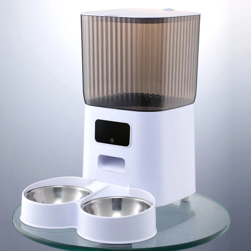 Vue de face d'un distributeur croquettes chat et chien blanc avec réservoir fumé protecteur et double gamelle en acier inoxydable. Le visuel présente le design épuré et le panneau de commande intuitif de l'appareil. Ce distributeur croquettes automatique assure une hygiène parfaite pour nourrir deux animaux en même temps. Idéal comme distributeur croquettes chien robuste pour une alimentation saine.