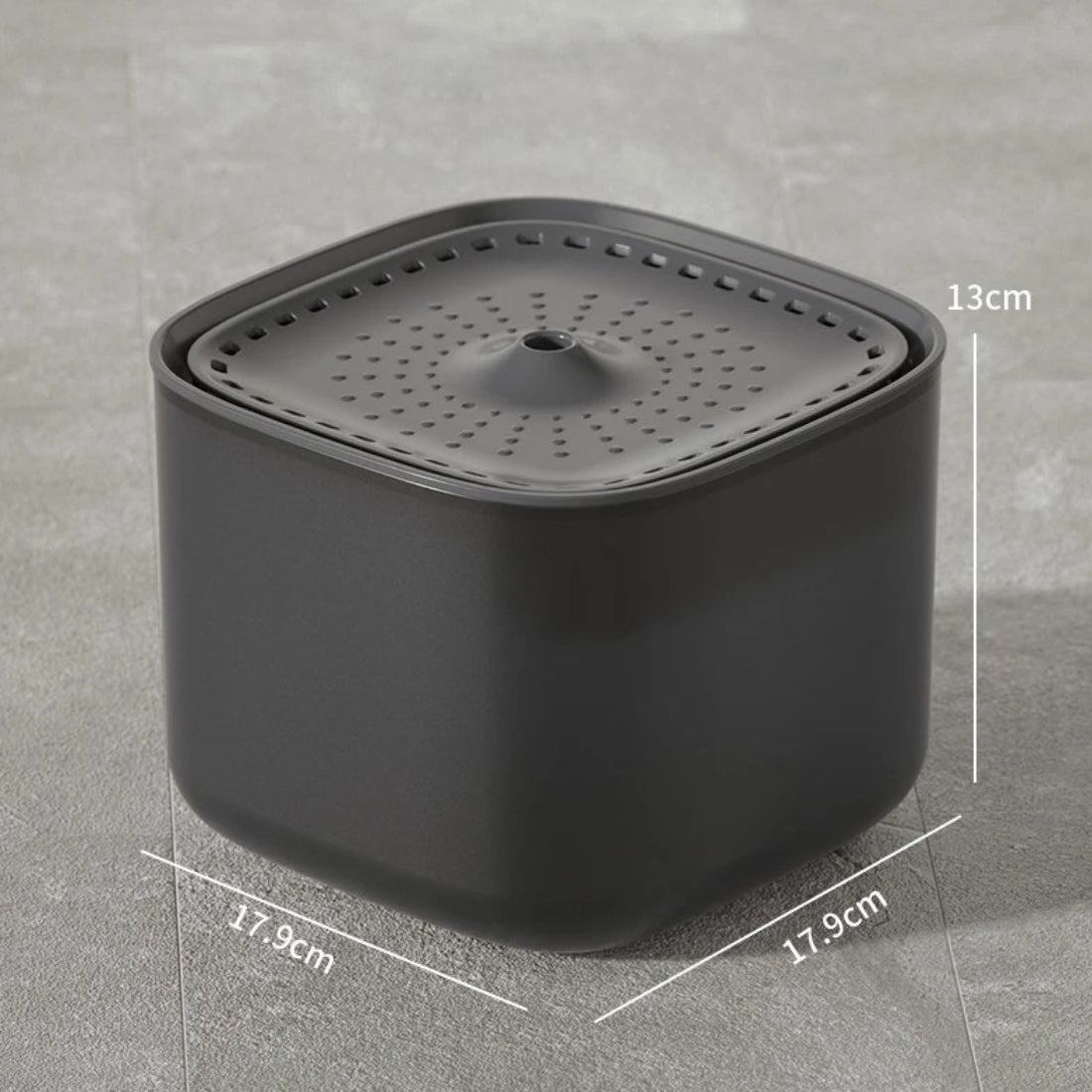 Fontaine à eau pour chat carrée gris anthracite avec dimensions : 17,9 cm de largeur par 13 cm de hauteur, plateau supérieur perforé et design minimaliste sur sol gris.