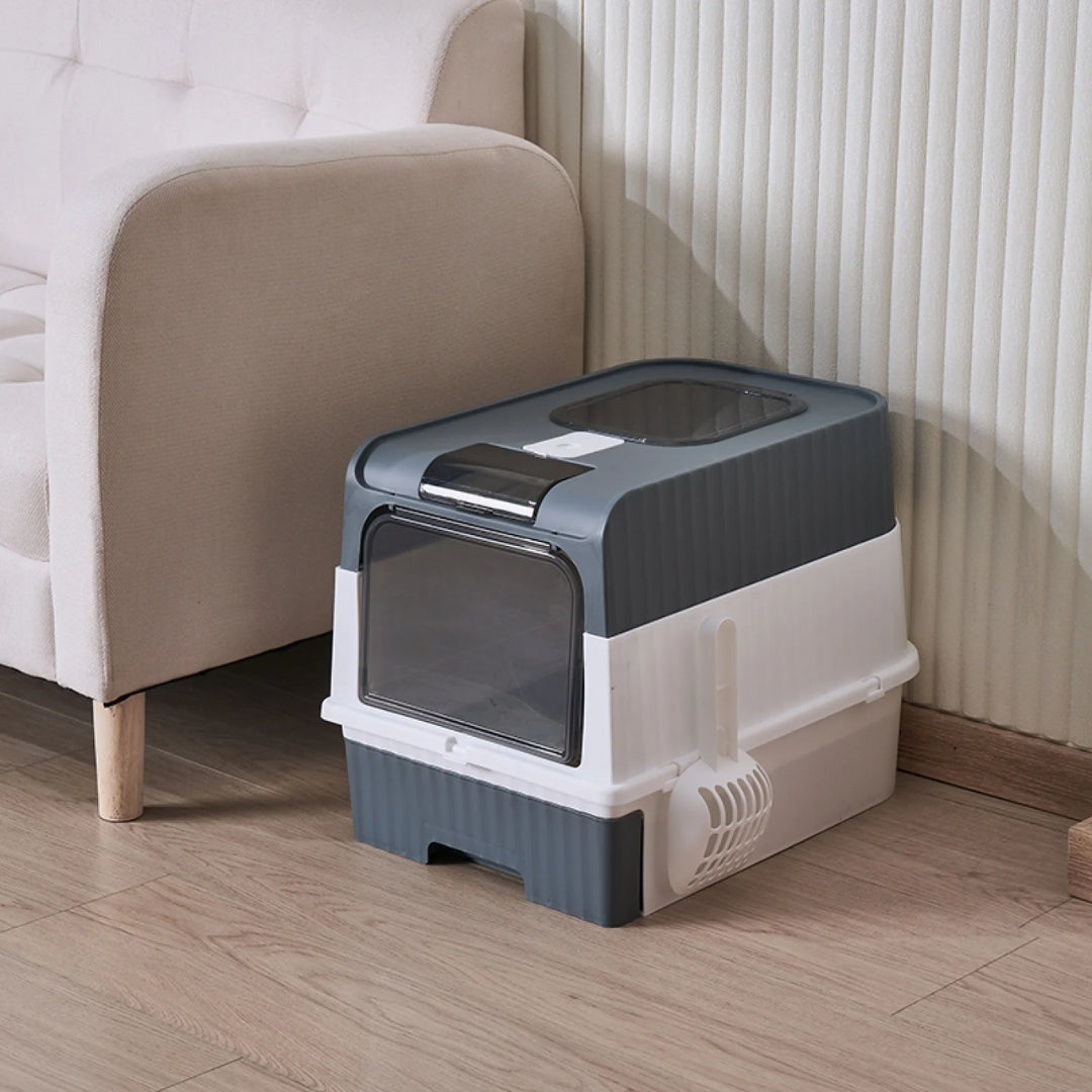 image de la litière cube grise posé dans un salon à coté d'un canapé