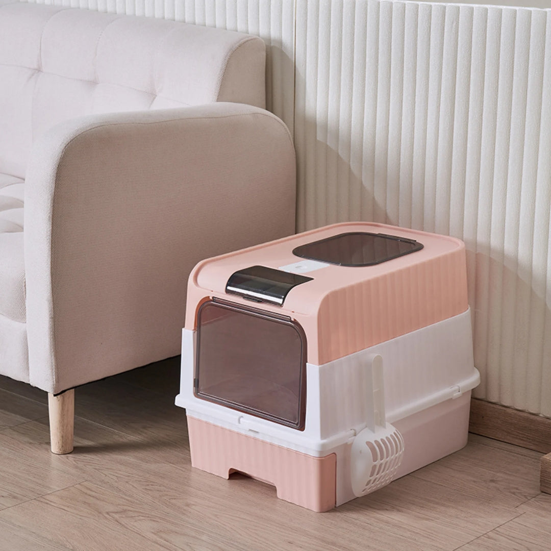 image de la litière cube rose posé dans un salon à coté d'un canapé