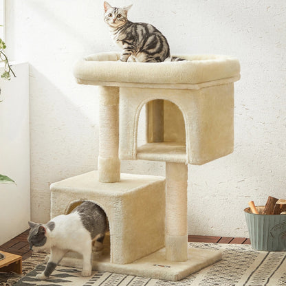 Arbre à chat beige crème avec deux niches cubiques superposées, plateforme d'observation rembourrée et poteaux griffoirs, présenté avec deux chats dans un salon chaleureux.