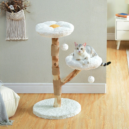 Arbre à chat design en bois naturel avec deux plateformes en forme de marguerites blanches, griffoir en corde de sisal et pompons suspendus, idéal pour une décoration d'intérieur zen.
