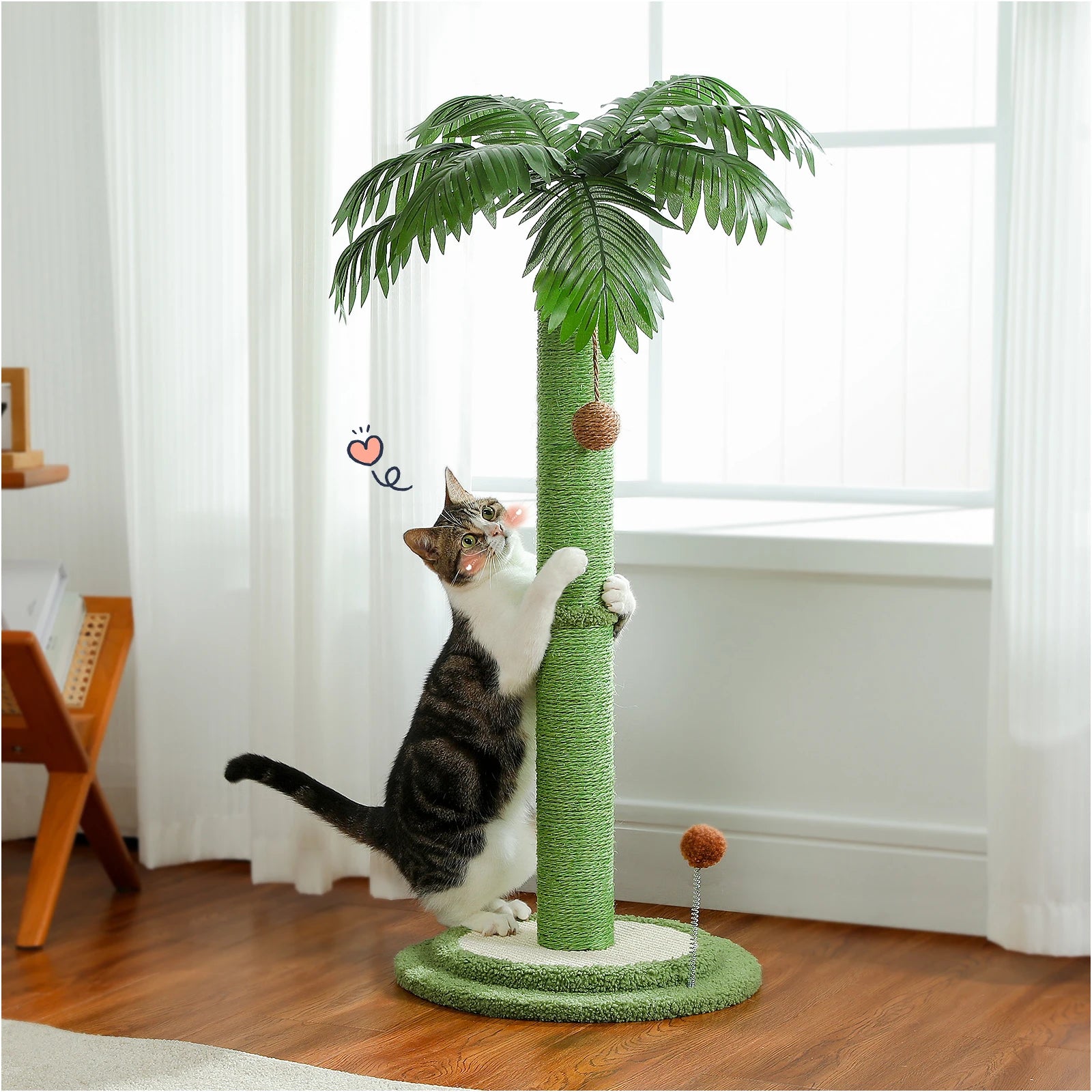 Arbre à chat design palmier exotique avec poteau central en sisal vert, feuilles tropicales réalistes et jouets suspendus, utilisé par un chat tigré dans un salon lumineux.