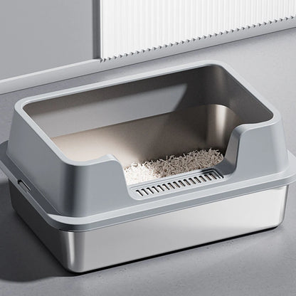 Vue de trois-quarts d'un bac à litière chat haut de gamme avec cuve en acier inoxydable et rebord haut gris mat. Comprend une entrée basse avec grille de nettoyage des pattes, parfait comme bac à litière pour chaton facile d'accès.