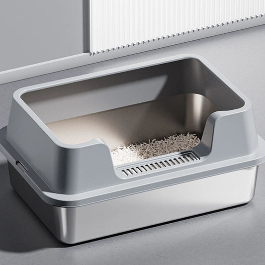 Vue de trois-quarts d'un bac à litière chat haut de gamme avec cuve en acier inoxydable et rebord haut gris mat. Comprend une entrée basse avec grille de nettoyage des pattes, parfait comme bac à litière pour chaton facile d'accès.