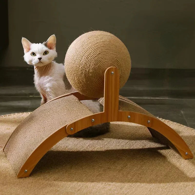 Chat blanc observant une station de griffage interactive comprenant une grande balle rotative en sisal naturel sur un support arqué en bois avec tunnel intégré.