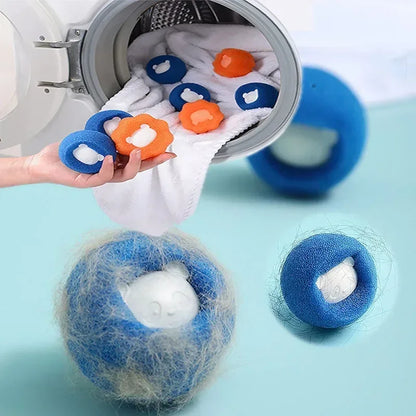 Photographie de démonstration montrant l'efficacité extrême des balles de lavage anti poils chat de la marque Les Trésors d'Owka. L'image met en avant une balle anti poils bleue recouverte d'une grande quantité de poils d'animaux capturés après un cycle en machine à laver. À l'arrière-plan, plusieurs balles collectrices (bleues et oranges) en forme de panda sont insérées dans le tambour d'un lave-linge avec du linge blanc. Ces accesoires chat indispensables utilisent une mousse haute densité pour emprisonne
