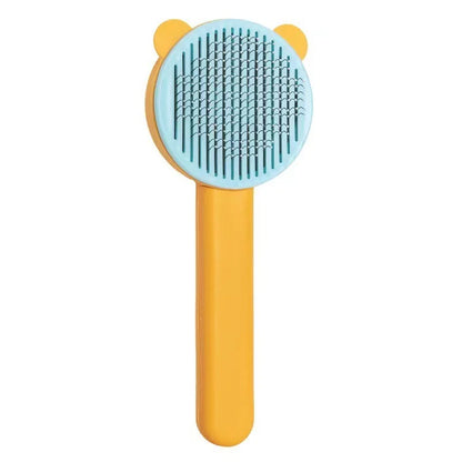 Brosse autonettoyante pour chat et chien, coloris jaune et bleu ciel, avec picots incurvés en acier inoxydable et design ludique à oreilles, vue de face sur fond blanc.