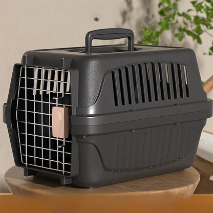 Caisse de transport rigide anthracite pour chat ou petit chien avec porte en grille métallique, système de verrouillage sécurisé à loquet rose et fentes de ventilation latérales.