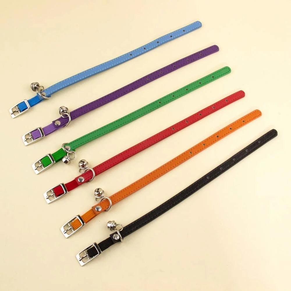 Présentation à plat d'une gamme de six colliers pour chat en cuir avec surpiqûres, couleurs bleu, violet, vert, rouge, orange et noir, dotés de boucles ardillon et grelots argentés.