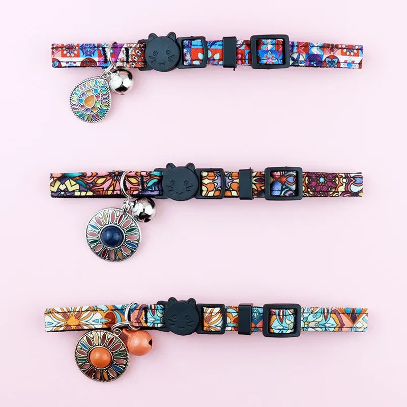 Vue détaillée de trois colliers pour chats ajustables aux motifs ethniques variés, montrant les boucles de réglage, les fermoirs de sécurité tête de chat et les pendentifs décoratifs assortis.