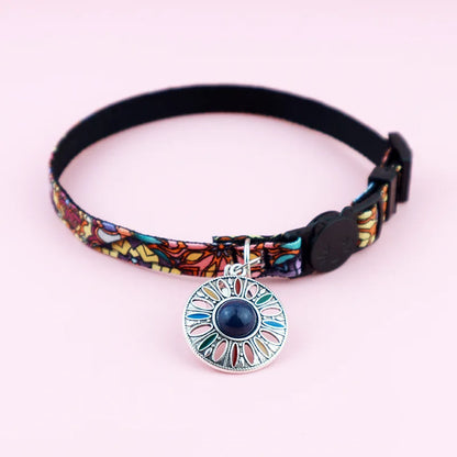 Collier pour chat ajustable au motif ethnique violet et bleu, doté d'un médaillon mandala gravé avec pierre centrale bleu foncé et fermoir de sécurité tête de chat.