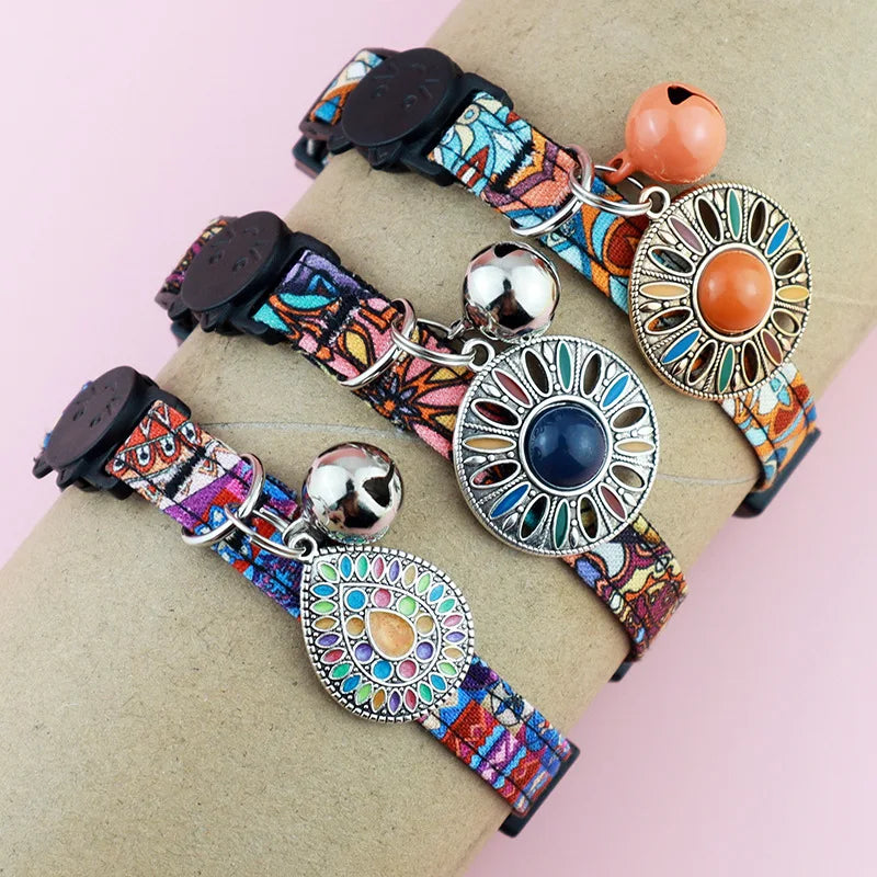 Collection de colliers pour chats aux motifs bohèmes et ethniques, présentés portés avec médaillons mandala colorés, clochettes argentées et cuivrées, et fermoirs de sécurité tête de chat.