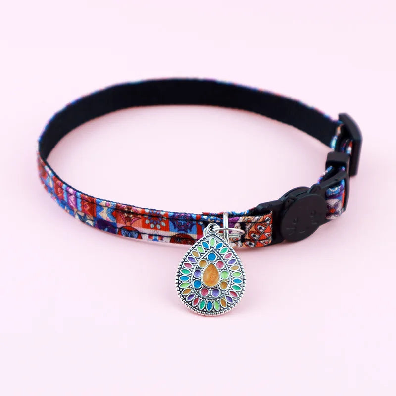 Collier pour chat ajustable au motif ethnique rouge et bleu, doté d'un médaillon mandala en forme de goutte nacrée multicolore et d'un fermoir de sécurité tête de chat.