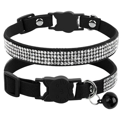 Gros plan d'un collier pour chat en velours noir orné de trois rangées de strass étincelants, doté d'une boucle de sécurité en forme de tête de chat et d'un grelot noir assorti.