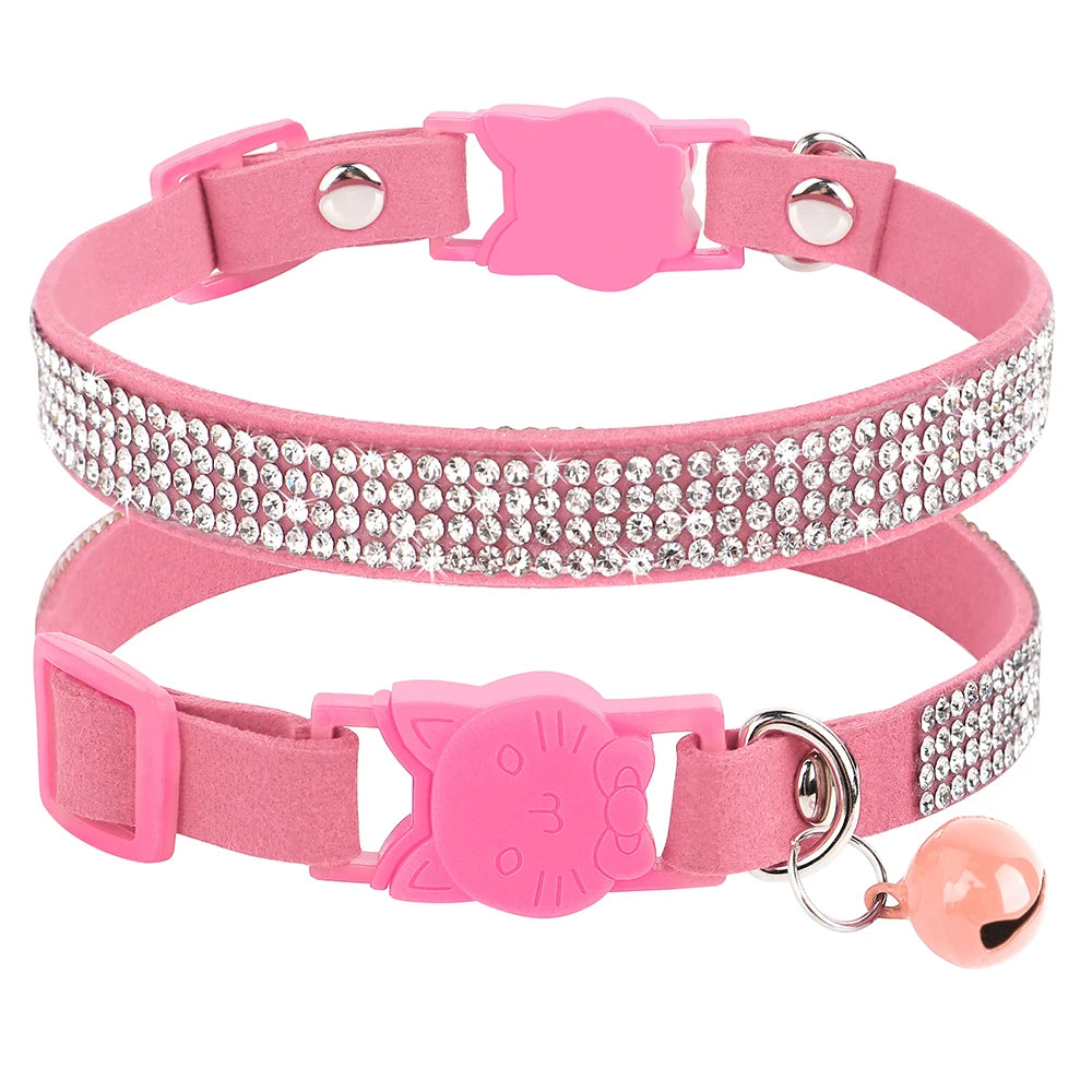 Gros plan d'un collier pour chat en velours rose orné de trois rangées de strass étincelants, doté d'une boucle de sécurité en forme de tête de chat et d'un grelot rose assorti.