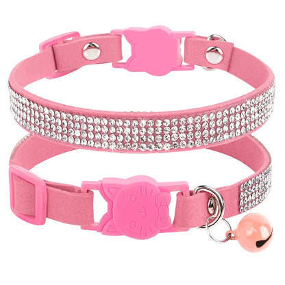 Gros plan d'un collier pour chat en velours rose orné de trois rangées de strass étincelants, doté d'une boucle de sécurité en forme de tête de chat et d'un grelot rose assorti.