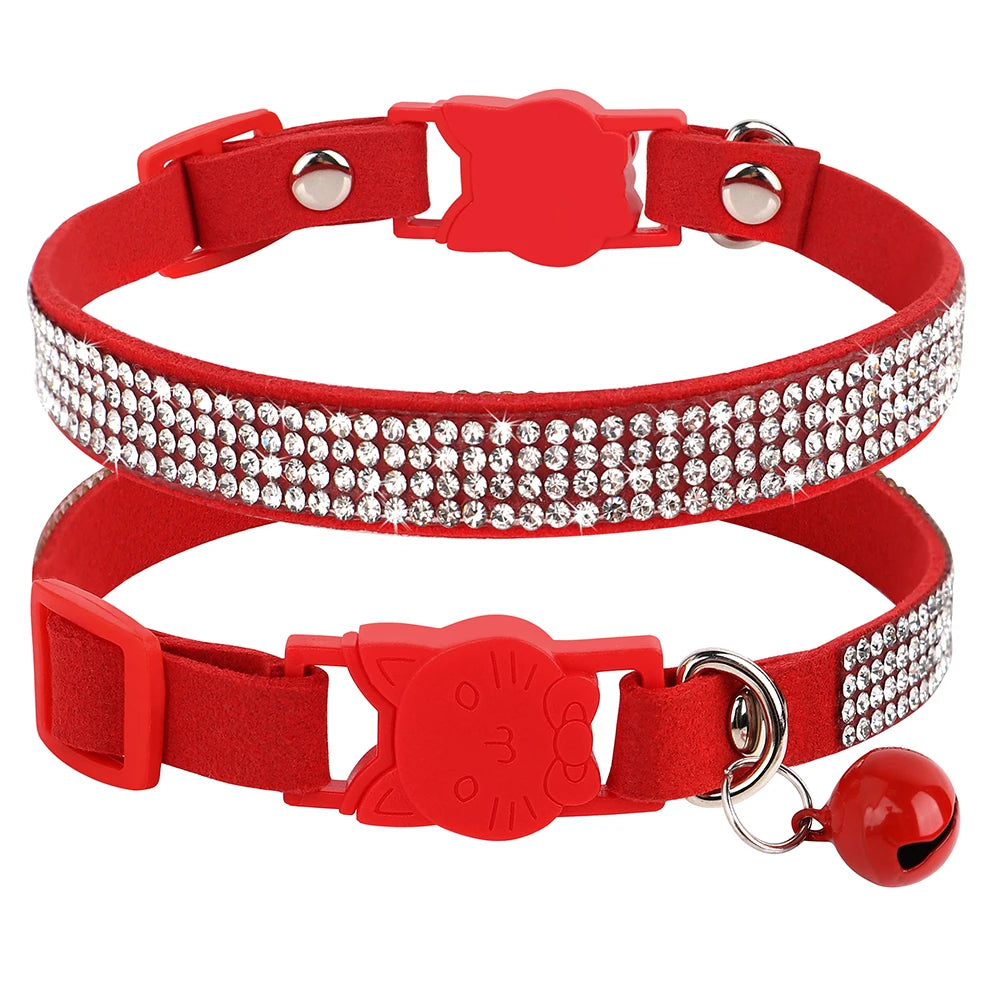 Gros plan d'un collier pour chat en velours rouge vif orné de trois rangées de strass étincelants, doté d'une boucle de sécurité rouge en forme de tête de chat et d'un grelot rouge assorti.