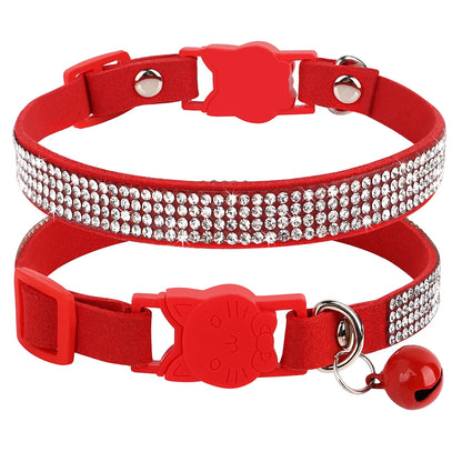 Gros plan d'un collier pour chat en velours rouge vif orné de trois rangées de strass étincelants, doté d'une boucle de sécurité rouge en forme de tête de chat et d'un grelot rouge assorti.
