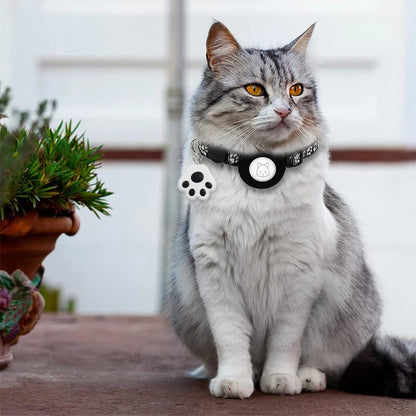 Collier gps chat noir à motifs pattes de chat, équipé d'un support de protection circulaire pour traceur et d'un pendentif décoratif en forme de patte blanche et noire. Porté par un chat gris et blanc, ce modèle illustre un collier gps pour chaton léger et ajustable. Un accessoire de suivi sécurisé qui allie style et technologie avec ce collier gps parfaitement adapté aux besoins des petits félins.