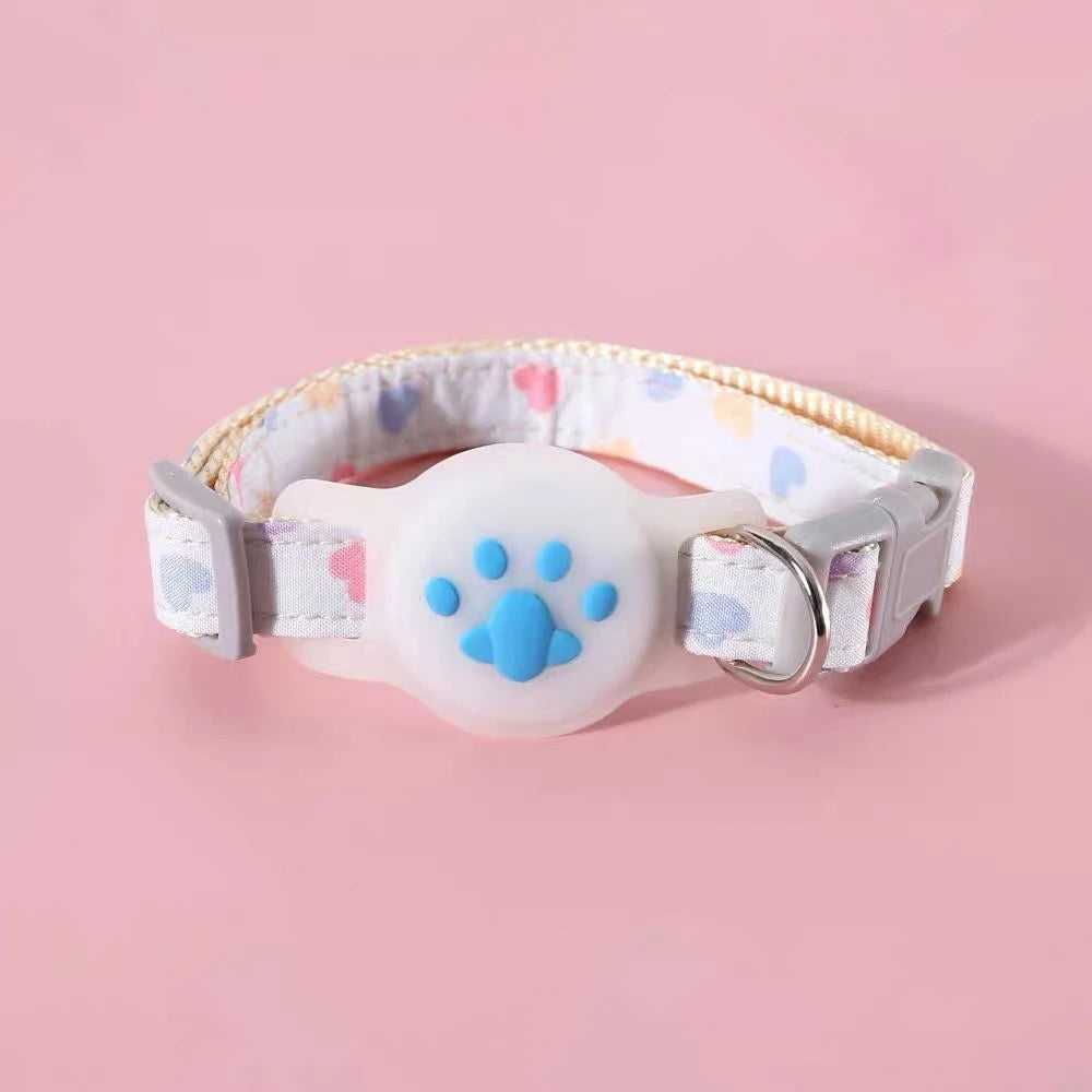 Collier gps pour chat bleu ciel à motifs cœurs pastels. Support AirTag en silicone blanc avec empreinte de patte de chat bleue en relief. Ce collier gps chat ajustable dispose d'une boucle de sécurité breakaway grise et d'un anneau en métal. Solution de protection type collier gps à chat alliant esthétique douce, confort et sécurité.