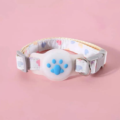 Collier gps pour chat bleu ciel à motifs cœurs pastels. Support AirTag en silicone blanc avec empreinte de patte de chat bleue en relief. Ce collier gps chat ajustable dispose d'une boucle de sécurité breakaway grise et d'un anneau en métal. Solution de protection type collier gps à chat alliant esthétique douce, confort et sécurité.