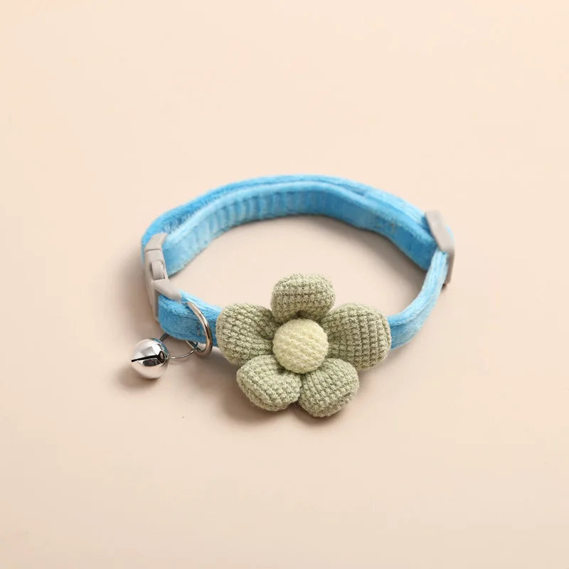Collier pour chat bleu azur en velours ultra-doux orné d'une fleur tricotée vert sauge. Ce collier chaton ajustable possède une clochette argentée et une boucle de sécurité. Accessoire confortable et léger pour collier chat au design artisanal et épuré. Les Trésors d'Owka.