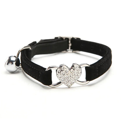 Collier pour chat noir en velours doux orné d'un pendentif cœur en strass brillants. Ce collier chaton chic et scintillant est équipé d'une boucle réglable et d'une clochette argentée. Accessoire réglable pour collier chat alliant élégance et confort. Les Trésors d'Owka.