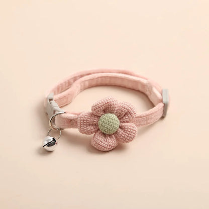 Collier pour chat rose poudré orné de broderies de fleurs bleues et roses. Vue d'un collier chaton ajustable muni d'un pendentif fleur rose bijou et d'un grelot doré. Accessoire confortable style kawaii pour collier chat. Les Trésors d'Owka.