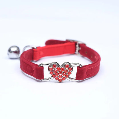 Collier pour chat rouge en velours doux orné d'un pendentif cœur en strass brillants. Ce collier chaton chic et scintillant est équipé d'une boucle réglable et d'une clochette argentée. Accessoire réglable pour collier chat alliant élégance et confort. Les Trésors d'Owka.