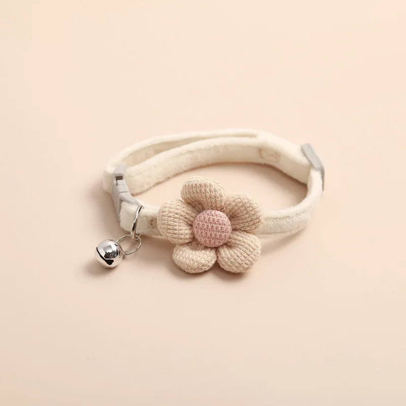 Collier pour chat de couleur crème en velours pelucheux avec une grande fleur tricotée beige et rose. Ce collier chaton ajustable comprend une clochette argentée et une boucle de sécurité. Accessoire de luxe confortable et élégant pour collier chat au style kawaii. Haute qualité Les Trésors d'Owka.