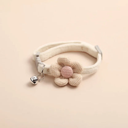 Collier pour chat de couleur crème en velours pelucheux avec une grande fleur tricotée beige et rose. Ce collier chaton ajustable comprend une clochette argentée et une boucle de sécurité. Accessoire de luxe confortable et élégant pour collier chat au style kawaii. Haute qualité Les Trésors d'Owka.
