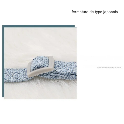 Gros plan sur la fermeture de type japonais et la boucle de réglage d'un harnais pour chat bleu en tissu tressé. Ce harnais chat ajustable offre un réglage précis pour un confort optimal et une sécurité anti-évasion. Un détail technique haut de gamme pour ce harnais animaux posé sur une texture douce, garantissant une ergonomie parfaite pour votre félin.