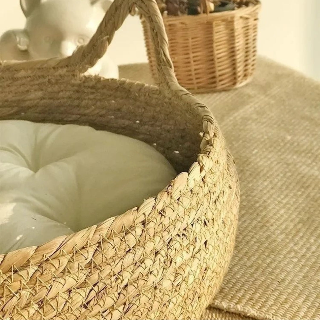 Gros plan sur le tressage artisanal d'un panier pour chat en osier naturel, montrant les détails de fabrication robustes et une poignée en forme d'oreille de chat.