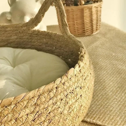 Gros plan sur le tressage artisanal d'un panier pour chat en osier naturel, montrant les détails de fabrication robustes et une poignée en forme d'oreille de chat.