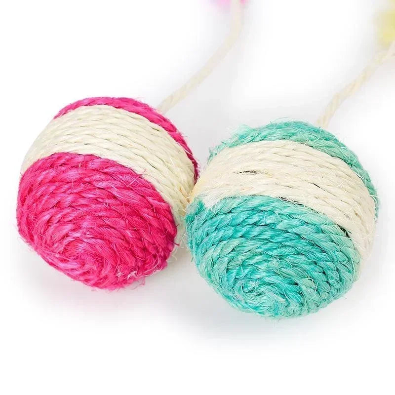 Gros plan sur deux balles pour chat en sisal naturel tressé de couleurs rose/blanc et vert/blanc, montrant la texture robuste du tressage bicolore pour l'entretien des griffes.