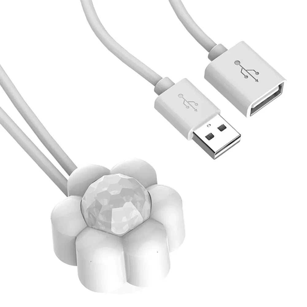 Détecteur de Mouvement Intelligent USB pour Fontaine à Eau Chat Les Trésors d'Owka. Gros plan sur le capteur blanc en forme de fleur avec connecteurs USB mâle et femelle. Accessoire universel pour Fontaine à Eau Chat automatique permettant d'économiser l'énergie de votre Fontaine à Eau.