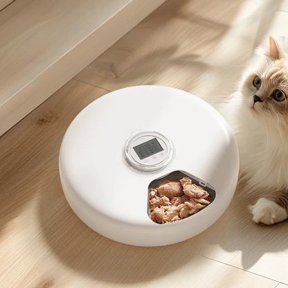 Distributeur automatique rotatif blanc pour chat contenant de la nourriture humide (pâtée), doté d'un écran LCD de programmation central et d'un compartiment de service ouvert.