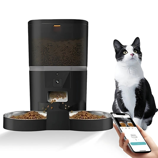 Distributeur automatique de croquettes noir avec séparateur pour deux gamelles en acier inoxydable, pilotable via application smartphone Wi-Fi, présenté avec un chat noir et blanc.
