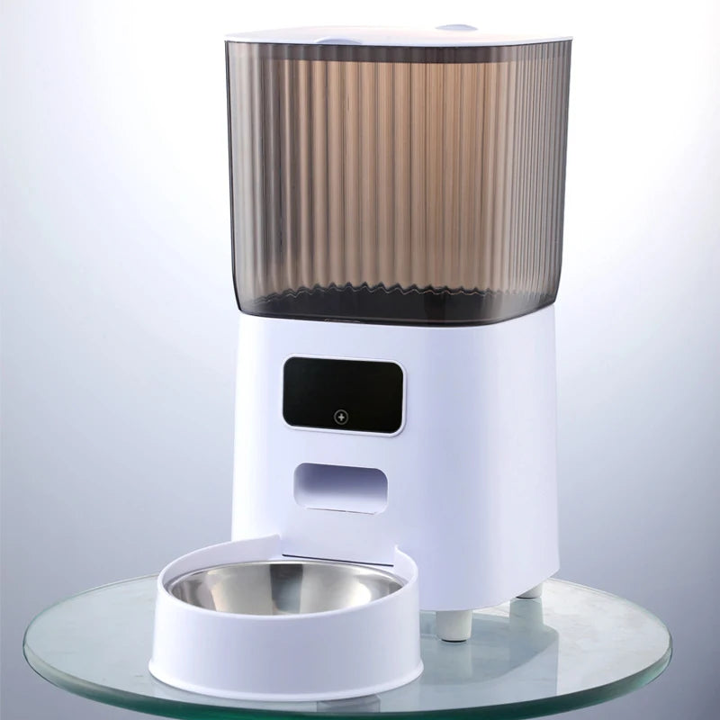 Vue de face d'un distributeur croquettes chat et chien blanc avec réservoir fumé protecteur et gamelle en acier inoxydable. Le visuel présente le design épuré et le panneau de contrôle intuitif de l'appareil. Ce distributeur croquettes automatique assure une hygiène parfaite et une conservation optimale des aliments. Idéal comme distributeur croquettes chien compact pour une alimentation saine et maîtrisée.