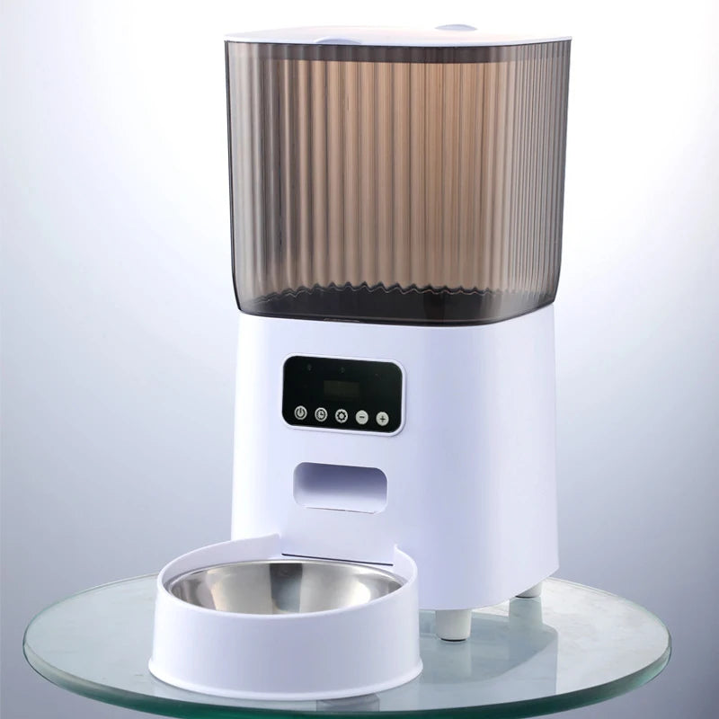 Vue de face d'un distributeur croquettes chat et chien blanc équipé d'une caméra HD de surveillance et d'un bol en acier inoxydable. Le visuel montre le panneau de contrôle intelligent et le réservoir fumé. Ce distributeur croquettes automatique Wi-Fi permet de nourrir et de filmer votre animal à distance. Idéal comme distributeur croquettes chien intelligent pour une gestion alimentaire connectée