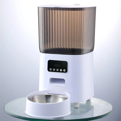 Vue de face d'un distributeur croquettes chat et chien blanc équipé d'une caméra HD de surveillance et d'un bol en acier inoxydable. Le visuel montre le panneau de contrôle intelligent et le réservoir fumé. Ce distributeur croquettes automatique Wi-Fi permet de nourrir et de filmer votre animal à distance. Idéal comme distributeur croquettes chien intelligent pour une gestion alimentaire connectée