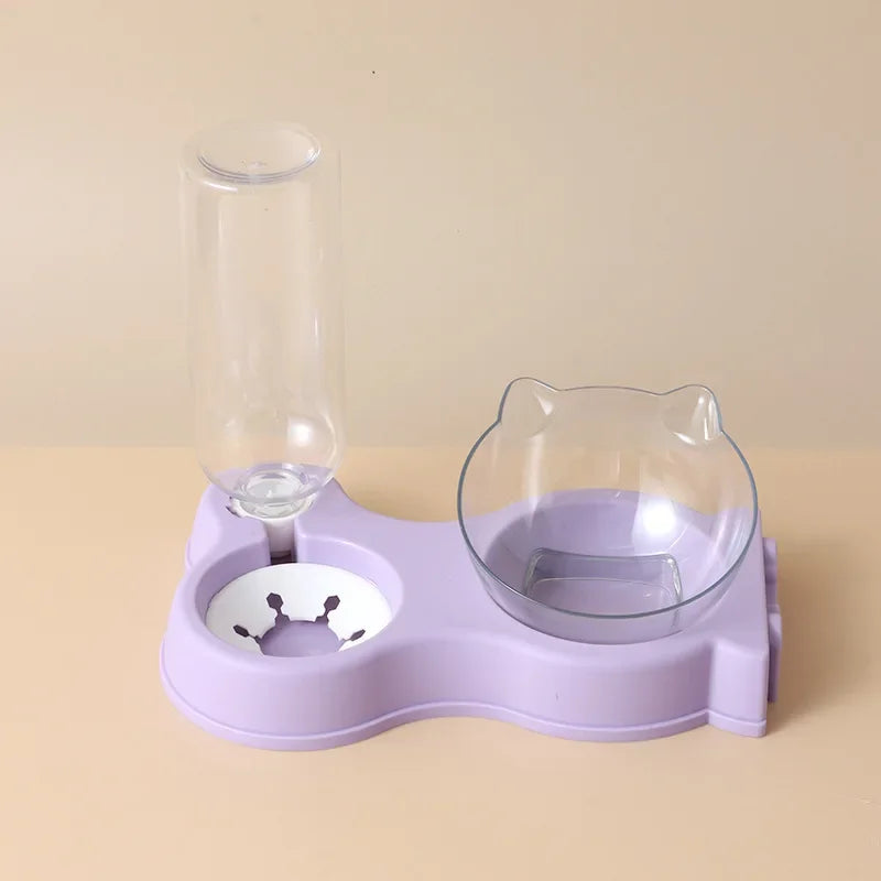 Vue de face d'un distributeur croquettes chat et chien 2-en-1 avec réserve d'eau automatique sur socle mauve pastel. Le visuel montre le flacon réservoir et la gamelle transparente inclinée en forme d'oreilles de chat. Ce distributeur croquettes par gravité assure une hydratation constante et un confort cervical. Parfait comme distributeur croquettes chien miniature pour une nutrition saine.