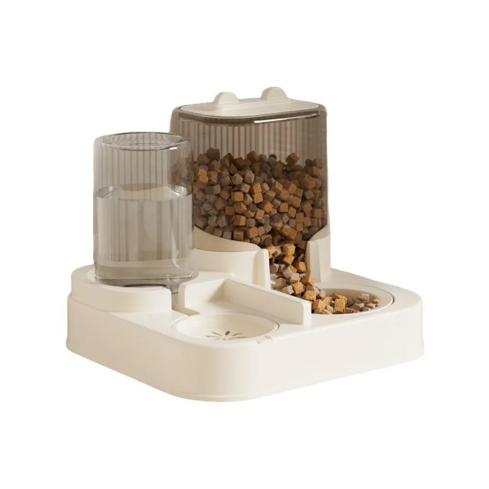 Station de nutrition 2-en-1 avec distributeur croquettes chat par gravité et réserve d'eau automatique. Le visuel montre les réservoirs striés gris fumé sur une base blanche stable. Ce distributeur croquettes manuel assure une distribution continue sans électronique. Idéal comme distributeur croquettes chien de petite taille pour une décoration d'intérieur moderne.