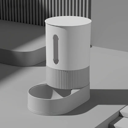 Vue de profil d'un distributeur croquettes chat et chien gris au design minimaliste et moderne. Le visuel met en avant le socle texturé strié et la fenêtre transparente pour le contrôle du niveau de nourriture. Ce distributeur croquettes automatique par gravité est une solution fiable et élégante sans piles. Parfait comme distributeur croquettes chien miniature pour un intérieur urbain et épuré.