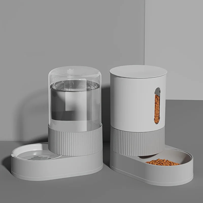 Duo de distributeur croquettes chat et abreuvoir automatique gris au design minimaliste strié. Le visuel montre le réservoir d'eau transparent et le distributeur de nourriture avec fenêtre de niveau. Ce distributeur croquettes par gravité assure une alimentation constante sans électricité. Idéal comme distributeur croquettes chien de petite taille pour un intérieur élégant.