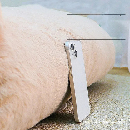Zoom sur l'épaisseur exceptionnelle d'un panier chat beige comparé à la taille d'un smartphone. L'image montre le rembourrage haute densité de ce coussin pour chat ultra-moelleux. Lit sofa épais, chaud et ferme pour un confort type coussin a chat premium. Expertise qualité Les Trésors d'Owka.