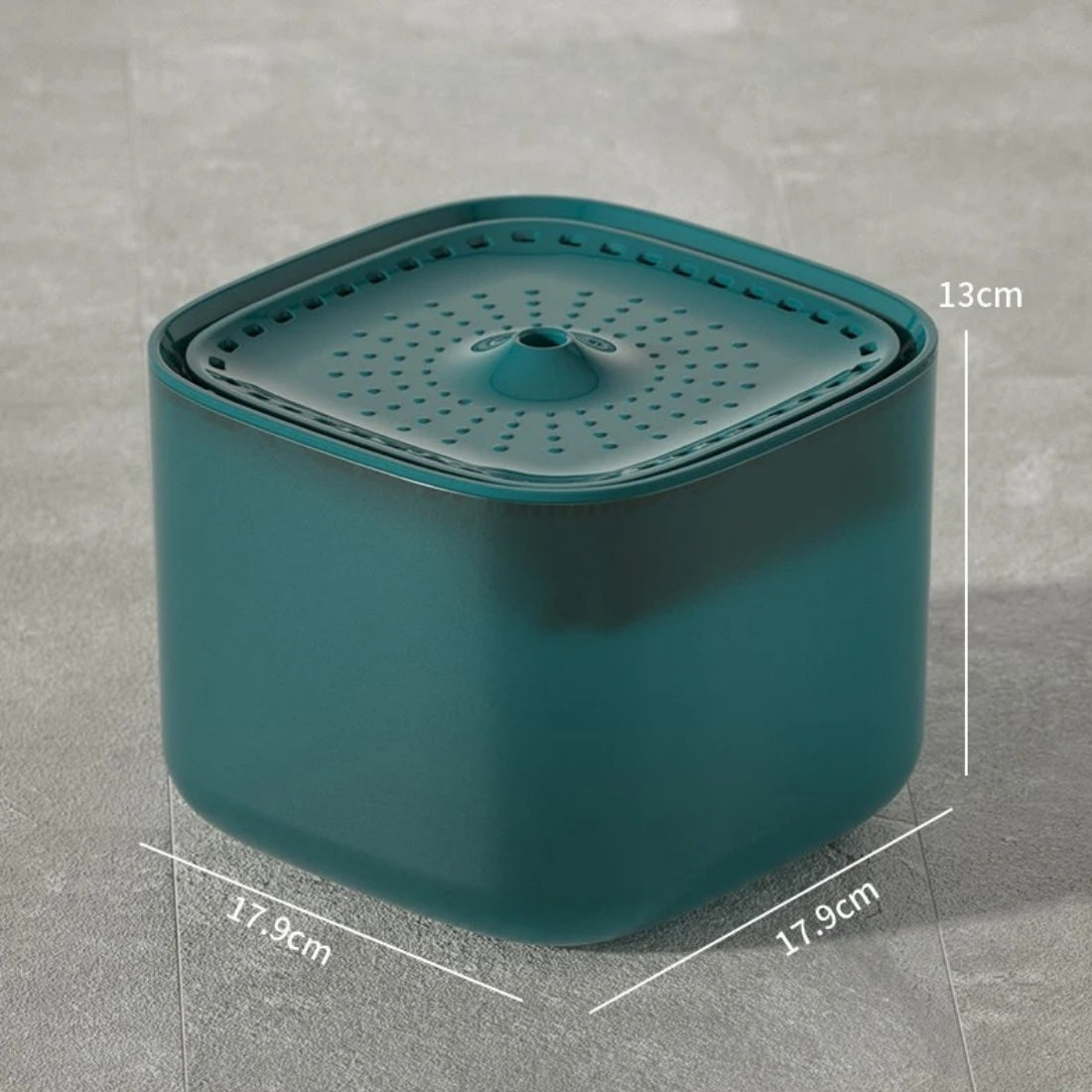 Fontaine à eau pour chat carrée bleu pétrole avec dimensions : 17,9 cm de largeur par 13 cm de hauteur, plateau supérieur perforé et design minimaliste sur sol gris.